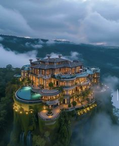 an aerial view of a luxurious mansion in the middle of foggy mountains at dusk