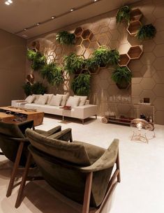 a living room filled with furniture and lots of greenery on the wall behind it