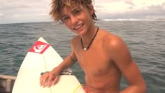 a young man holding a surfboard in the water