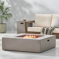 an outdoor fire pit sitting on top of a white tile floor next to a couch