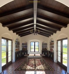 a large room with many bookshelves and a rug on the floor in front of it