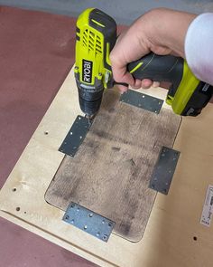 a person using a power drill to attach a piece of plywood on the floor