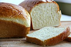 a loaf of bread sitting on top of a cutting board next to a slice of bread