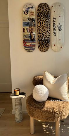 two skateboards mounted to the wall above a chair and table with pillows on it