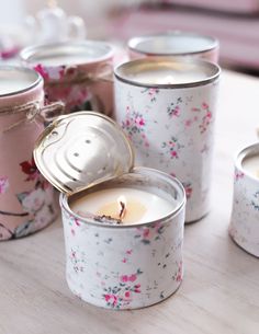 several tins with candles in them sitting on a table