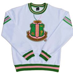 a white sweater with green and pink trims on the front, featuring an emblem