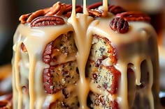 a bundt cake with pecans on top and frosting drizzled over it