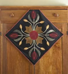 a wooden cabinet with a black and red design on it