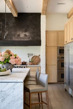 a kitchen with marble counter tops and wooden cabinetry, along with stainless steel appliances