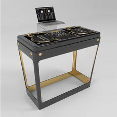 a laptop computer sitting on top of a black and gold table with two speakers in front of it