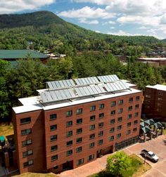 an aerial view of a red brick building with solar panels on it's roof