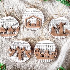 four wooden christmas ornaments hanging on a sheet of music with the words joy to the world