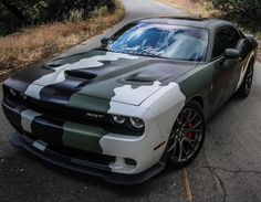 a white and black camo car is parked on the side of the road