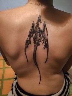 a woman with a dragon tattoo on her back