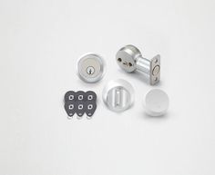 an assortment of door knobs and locks on a white surface