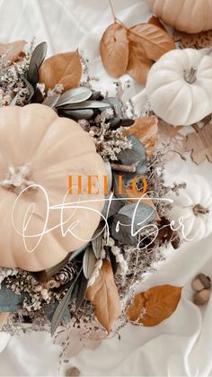 a white table topped with lots of pumpkins and leaves