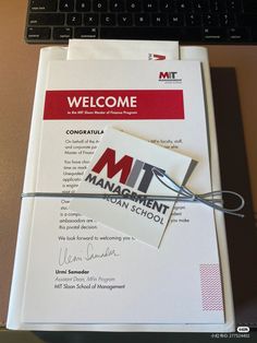 a computer keyboard sitting on top of a desk next to a paper with the words mti management school written on it