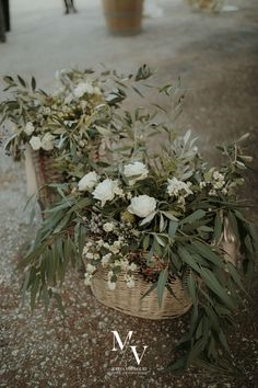 two baskets filled with flowers sitting on top of a cement floor next to each other