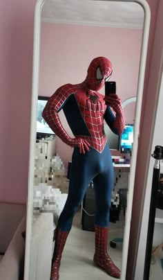 a man in a spiderman costume taking a selfie