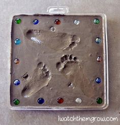 an animal paw and foot print is shown in the middle of a tin tray with colored glass beads on it