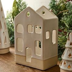 three ceramic houses sitting on top of a wooden table