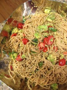 a bowl filled with noodles and vegetables on top of a table