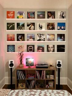 there is a wall with many pictures on it and speakers in front of the bookshelf