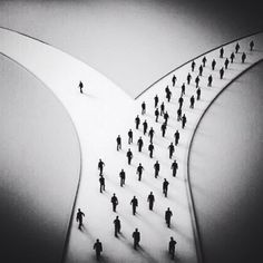 a group of people walking across a bridge in the snow