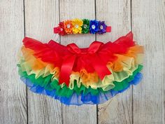 a rainbow colored tutule and headband on a wooden surface