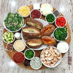 a platter filled with lots of different types of food on top of a wooden plate