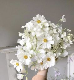 a hand holding a bouquet of white flowers