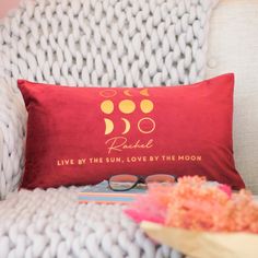 a red pillow sitting on top of a white chair