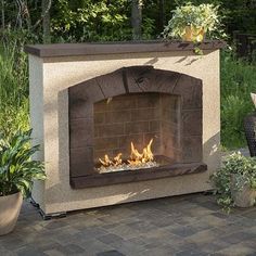 an outdoor fireplace in the middle of a garden