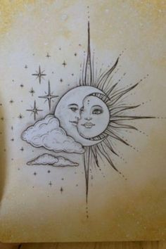 a drawing of the sun and moon on a piece of paper that is sitting on a table