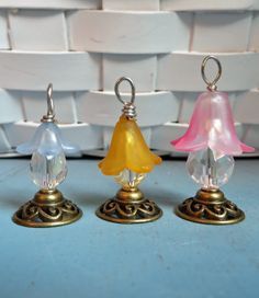 three glass bell ornaments sitting on top of a table