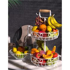 three tiered baskets filled with fruit on top of a table