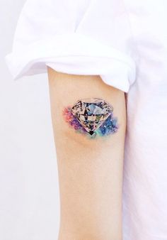 a woman's arm with a diamond tattoo on it