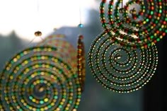 a close up of a wind chime hanging from a window with beads on it