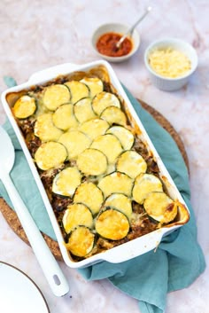 a casserole dish with zucchini and cheese in it on a table