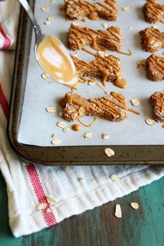 peanut butter and oatmeal cookies on a baking sheet with a spoon in it