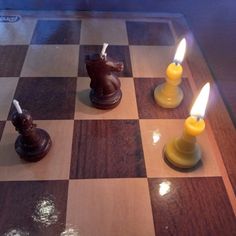 three chess pieces with candles on top of them