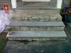 three stone steps leading up to a house