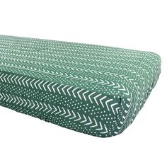 an image of a green and white bed cover with arrows on the bottom, side view