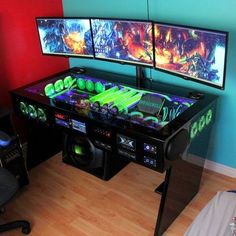 two computer monitors sitting next to each other on top of a wooden floor in front of a blue wall