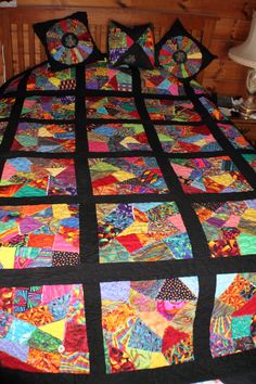 a bed with a colorful quilt on top of it