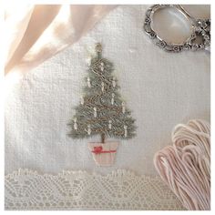 there is a christmas tree on the table next to some scissors and thread, along with other items