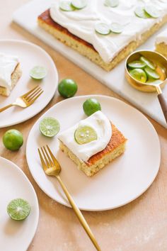 there is a piece of cake on the plate with limes and cucumbers around it