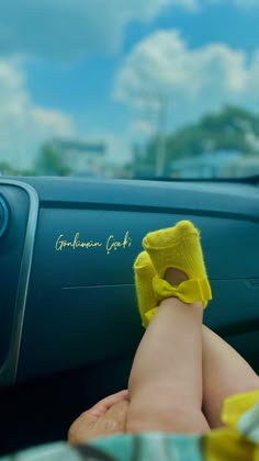 a person's feet with yellow socks on in the back seat of a car