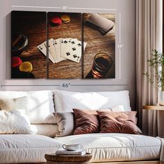 a living room with a white couch and three pieces of art hanging on the wall