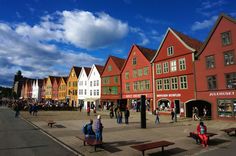 people are sitting on benches in front of red buildings